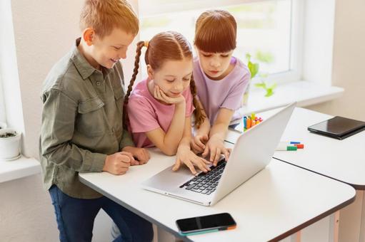 パソコンを見る生徒たちと太陽 男の子,女の子,子どもの写真素材