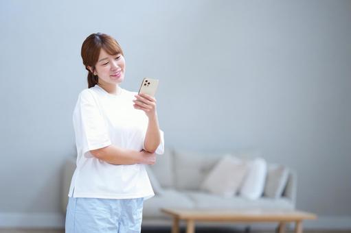 スマホを見て笑う女性 女性,スマートフォン,持つの写真素材
