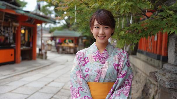 神社の境内にいる浴衣姿の若い女性 神社の境内にいる浴衣姿の若い女性の写真