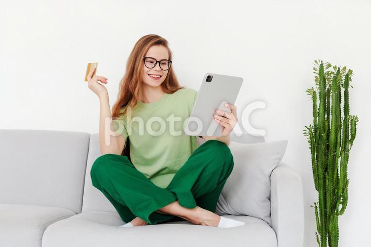 タブレットを見ながらカードを持つ女性 女性,タブレット,見るの写真素材