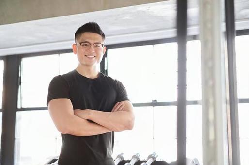 Asian male trainer with a smile and arms folded Asian male trainer with a smile and arms folded