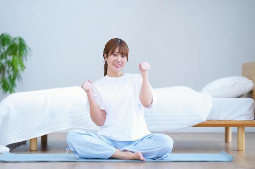 カメラ目線でベンベルを持つ女性 女性,ダンベル,持つの写真素材