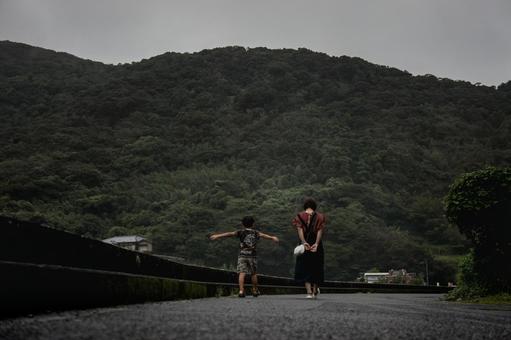 ＜素材＞雨上がりの道を散歩する親子 家族,子供,女性の写真素材