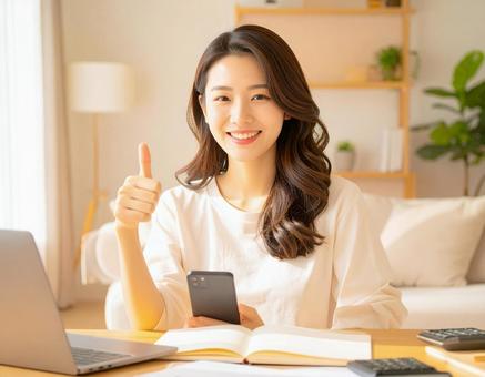 家計がうまくいきスマホ片手に微笑む女性 家計がうまくいきスマホ片手に微笑む女性の写真