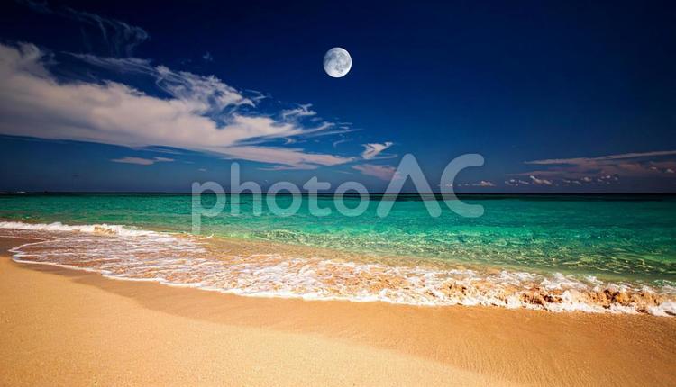 ビーチの青空に浮かぶ透けた白い月 月,砂浜,ビーチの写真素材