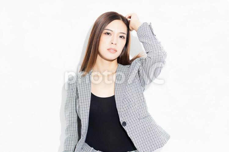 白い背景の前に立ってポーズをとるビジネスウーマン 女性,白背景,立つの写真素材