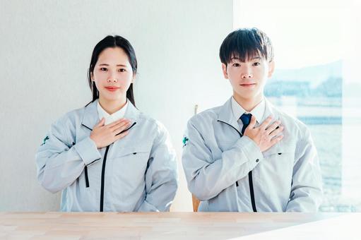 作業着を着た男女が胸に手を当てる 作業着を着た男女が胸に手を当てる 作業服,作業着,働く男女の写真素材