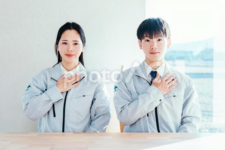 作業着を着た男女が胸に手を当てる　 作業服,作業着,働く男女の写真素材