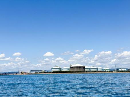 海から望む工業地帯の大型タンクの建物 海から望む工業地帯の大型タンクの建物 波,海,青空の写真素材