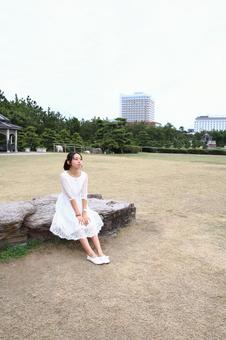 広場に座り遠くを見る女性 女性,座る,広場の写真素材