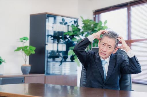 業績不振に頭を抱える経営者の男性 男性,マネジメント,悩みの写真素材
