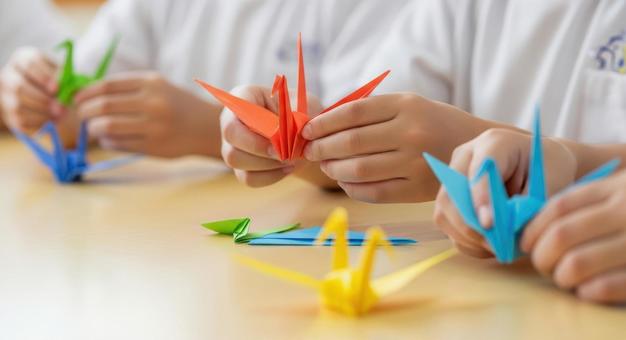子供(園児)がカラフルな折り鶴を折る様子 子供(園児)がカラフルな折り鶴を折る様子の写真
