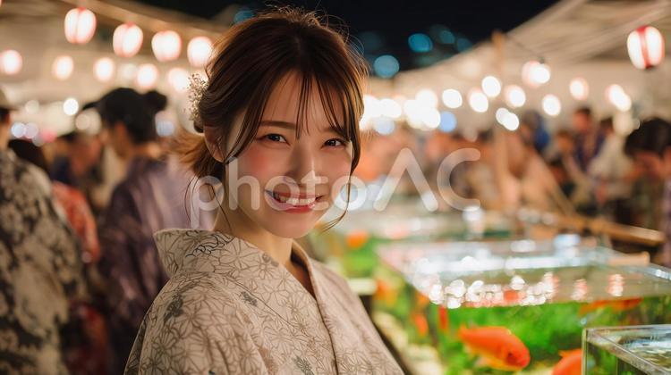 夏祭りを見て楽しむ浴衣を着た女性 夏祭り,浴衣,金魚の写真素材