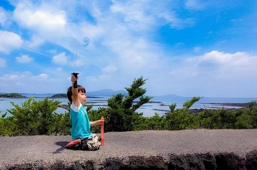 <素材>公園でシャボン玉を飛ばす男の子 <素材>公園でシャボン玉を飛ばす男の子の写真