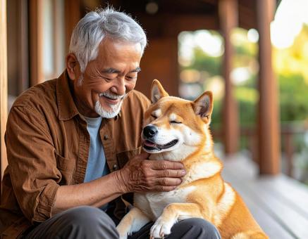 柴犬と触れ合う笑顔の高齢男性の写真