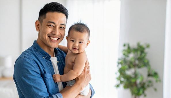 赤ちゃんを抱える若いパパ 赤ちゃんを抱える若いパパの写真