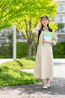 キャンパスを歩く女子大学生 キャンパスを歩く女子大学生 キャンパス,大学,大学生の写真素材