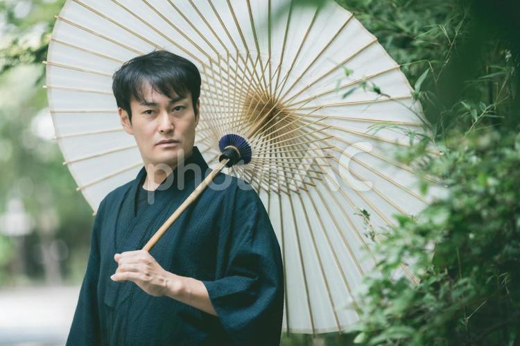 番傘を持った浴衣姿の男性（真剣） 浴衣,和装,男性の写真素材