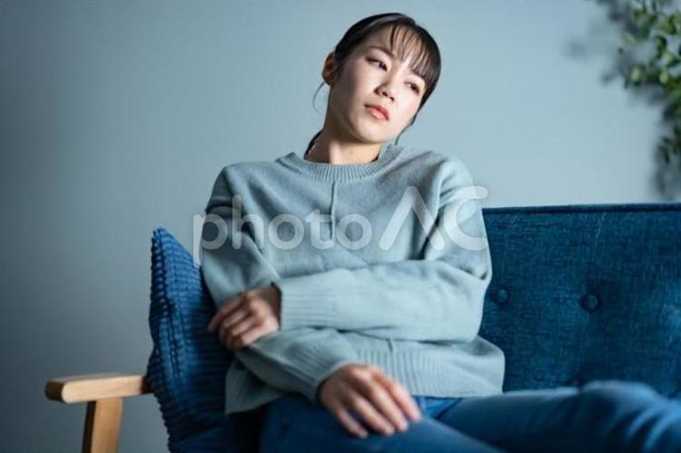 ソファで落ち込む女性 女性,ソファー,夜の写真素材