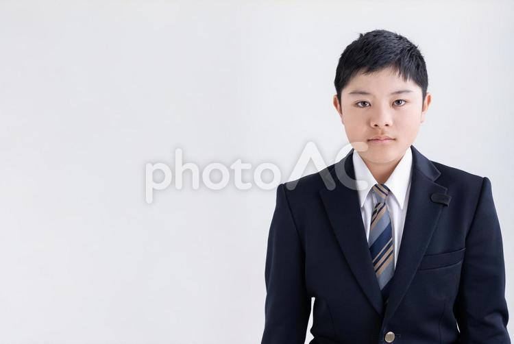 カメラ目線で真剣な表情の男子学生 男性,学生,制服の写真素材