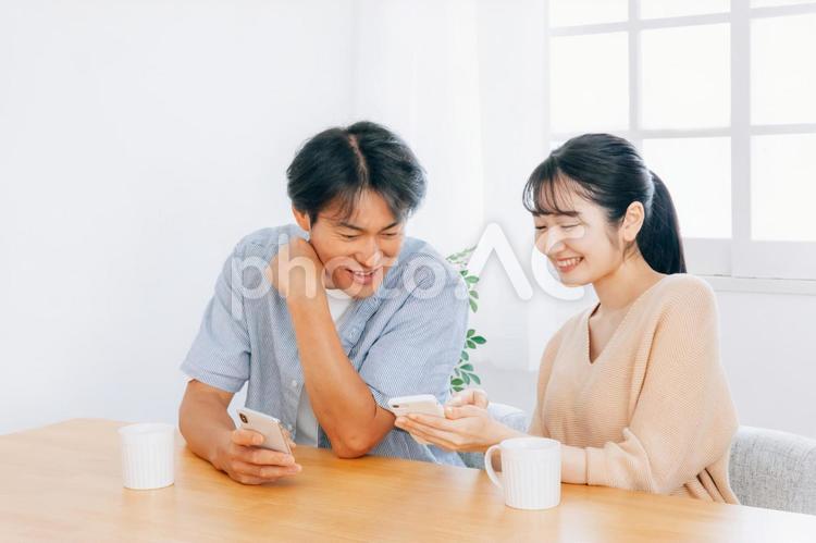 スマホを見る夫婦（笑顔） スマホ,夫婦,カップルの写真素材