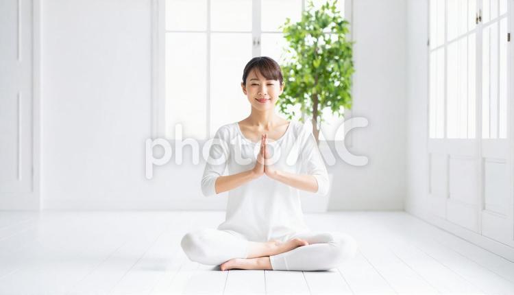 室内で瞑想ポーズをとる笑顔のアジア人女性 人物,女性,若いの写真素材