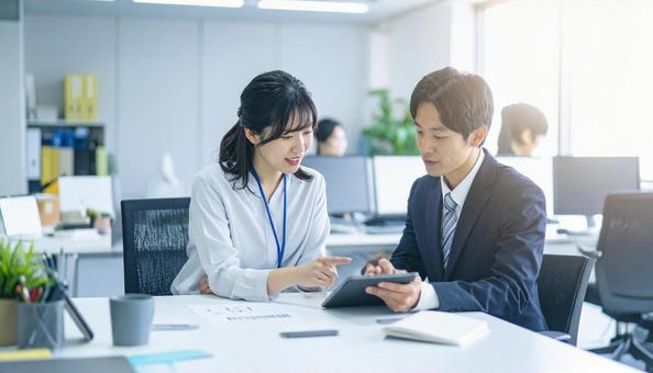 タブレットで打ち合わせするビジネス社員 タブレットで打ち合わせするビジネス社員の写真