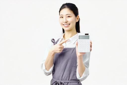 電卓を持つ主婦 エプロンの女性 電卓を持つ主婦 エプロンの女性 主婦,計算機,電卓の写真素材