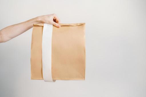 紙袋を差し出す手 配達,フードデリバリー,テイクアウトの写真素材