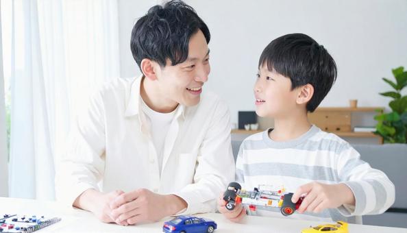 父親と一緒にプラモデルを作る男の子 父親と一緒にプラモデルを作る男の子の写真