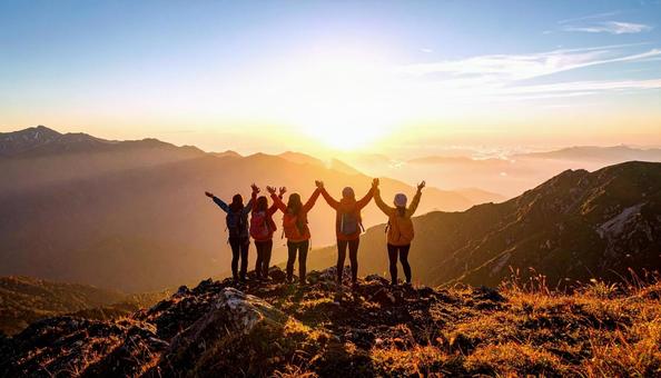 夏山で朝日に向かって手をあげる登山者 夏山で朝日に向かって手をあげる登山者の写真