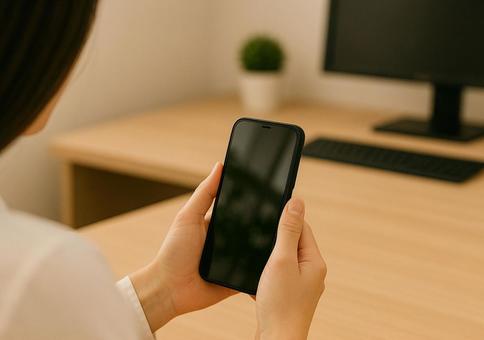 スマホを見ている女性の手元 2 スマホを見ている女性の手元 2の写真