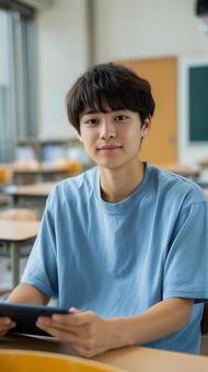 教室でタブレット学習に取り組む男子学生 教室でタブレット学習に取り組む男子学生の写真
