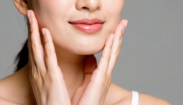 両手で頬を触る日本人女性　美容イメージの写真