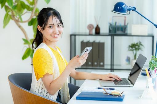 スマホを操作する若い女性 ビジネスウーマン,若い女性,笑顔の写真素材