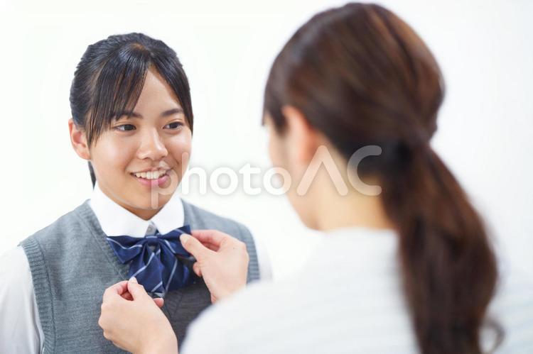 娘の制服のリボンを整えるお母さん 人物,女の子,女子生徒の写真素材