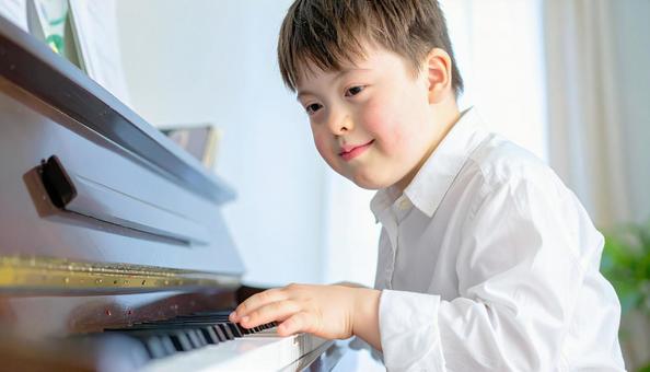 ピアノを弾くダウン症の少年 ピアノを弾くダウン症の少年の写真