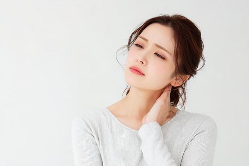 目を閉じて痛みに耐える女性の素材の写真