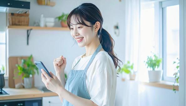 スマホでポイ活する笑顔の女性 スマホでポイ活する笑顔の女性の写真
