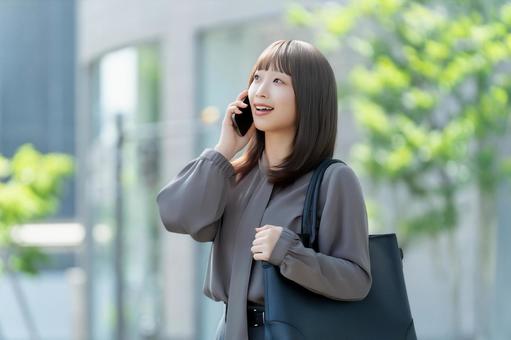 スマホで話す笑顔の女性・ビジネスウーマン 女性,スマホ,スマートフォンの写真素材