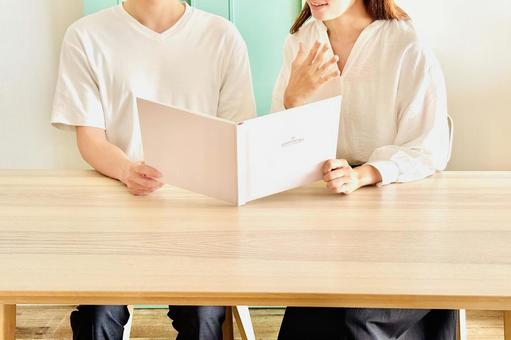 思い出のアルバムを見て懐かしむ男女 思い出のアルバムを見て懐かしむ男女の写真