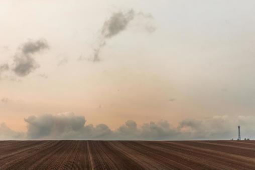 夕暮れの畑と鉄塔の写真