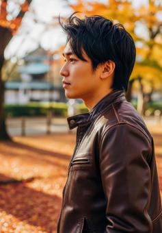 秋色に染まる公園で散歩するおしゃれな男性 秋色に染まる公園で散歩するおしゃれな男性の写真