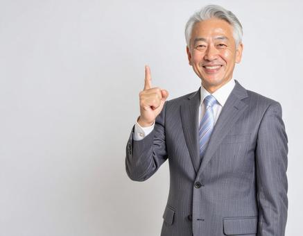 人差し指を上げて閃くスーツの中年男性 人差し指を上げて閃くスーツの中年男性の写真