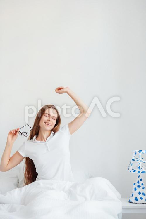 目を閉じ腕を伸ばす女性 女性,目覚める,メガネの写真素材