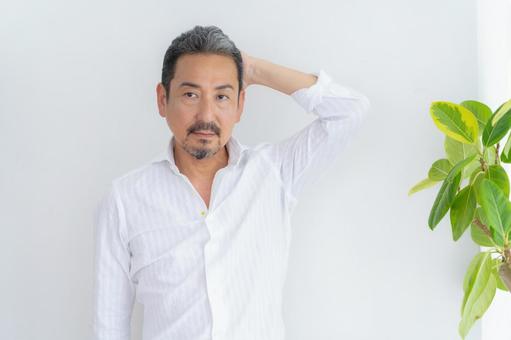 リビングでヘアケアをするミドルの男性 ヘアケア,育毛,ビューティーの写真素材