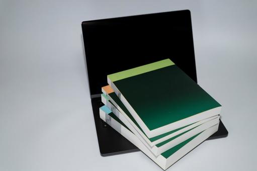 ノートパソコンの手前に積まれた書籍 本,ノートパソコン,学習の写真素材