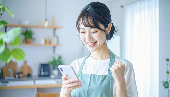 スマホでポイ活する笑顔の女性 スマホでポイ活する笑顔の女性の写真