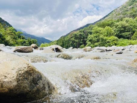 岩場を流れる清流と緑深い山々 清流,川,渓流の写真素材
