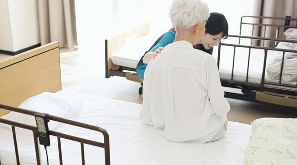 高齢者の体位変換を行うアジア人介護士 高齢者の体位変換を行うアジア人介護士 介護士,高齢者,体位変換の写真素材